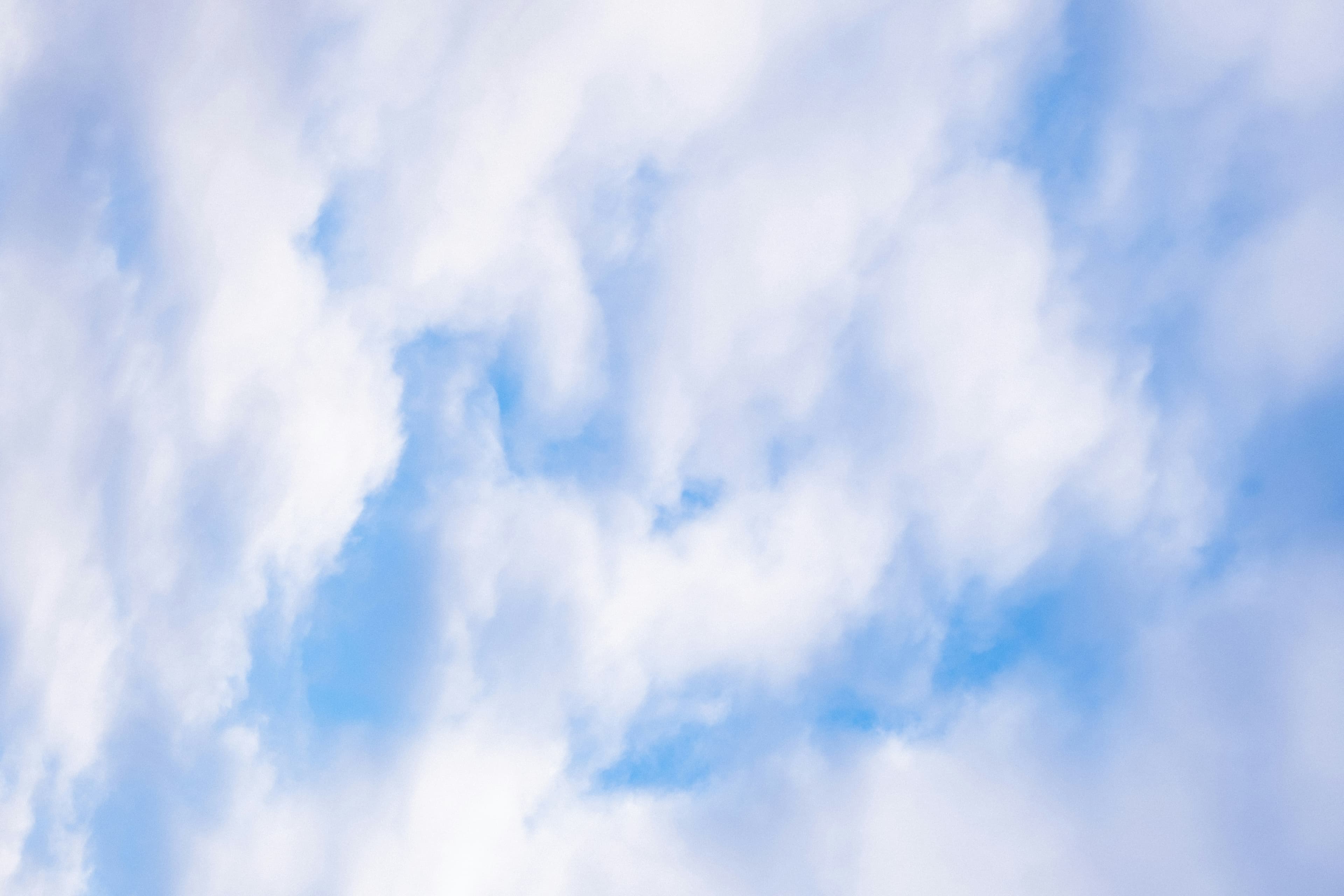 A bright sky filled with soft, open clouds
